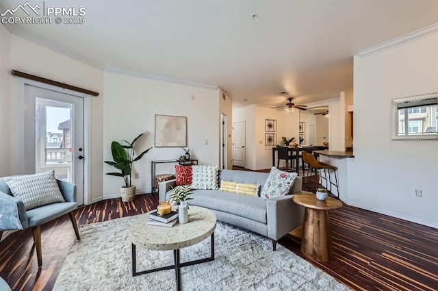 living room with wood-type flooring, ornamental molding, and ceiling fan