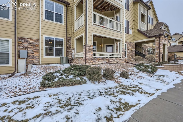 snow covered property entrance featuring cooling unit