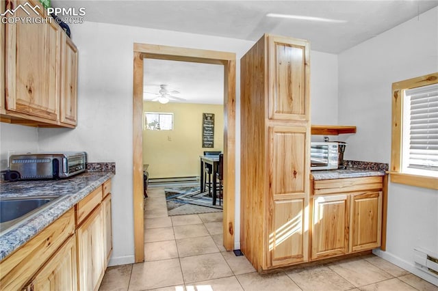 kitchen featuring light tile patterned flooring, light brown cabinets, and ceiling fan