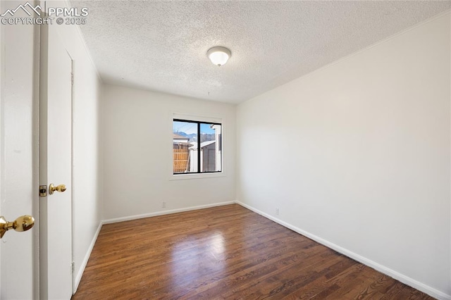 empty room with a textured ceiling and dark hardwood / wood-style flooring