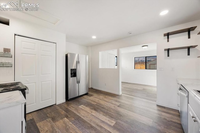 kitchen with appliances with stainless steel finishes, white cabinets, and dark hardwood / wood-style flooring