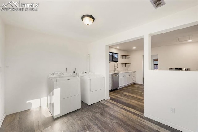 washroom with sink, dark wood-type flooring, and independent washer and dryer