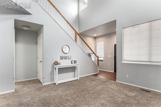 entrance foyer with carpet floors and a towering ceiling