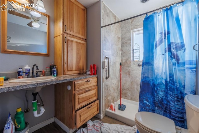 bathroom with a shower with curtain, ceiling fan, toilet, and sink