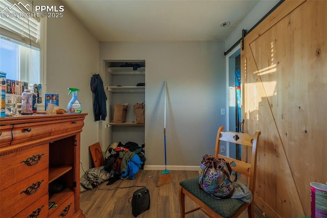 bedroom with hardwood / wood-style flooring and a barn door