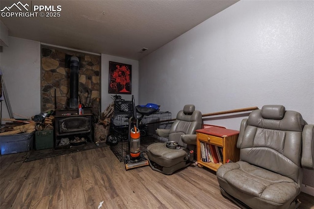 living area featuring hardwood / wood-style flooring and a wood stove