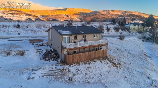 snow covered house featuring a mountain view