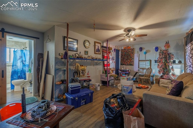 living room with wood-type flooring, a textured ceiling, and ceiling fan