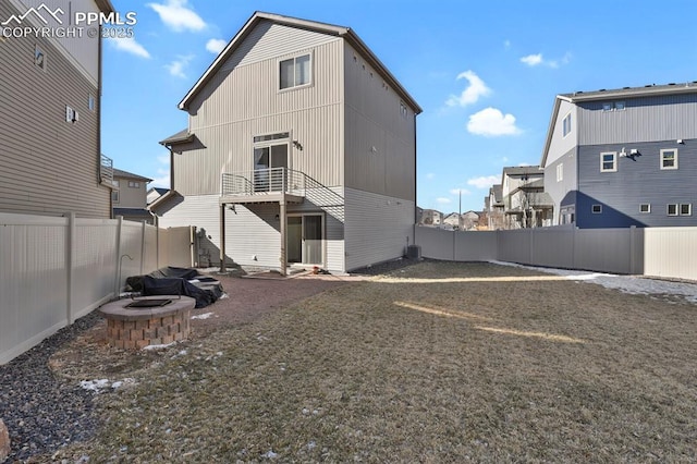 rear view of house with cooling unit and an outdoor fire pit