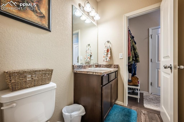 bathroom with hardwood / wood-style floors, toilet, and vanity