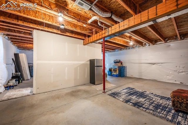 basement featuring stainless steel fridge