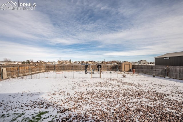 yard covered in snow featuring a storage unit