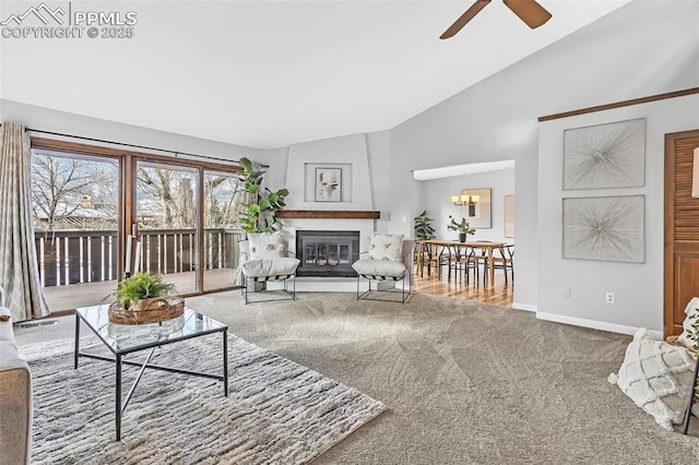 carpeted living room with vaulted ceiling and ceiling fan