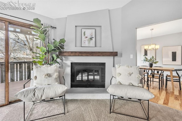 living area featuring hardwood / wood-style flooring, vaulted ceiling, and a notable chandelier