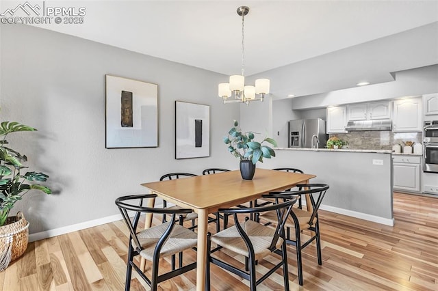 dining room featuring light hardwood / wood-style flooring and a chandelier