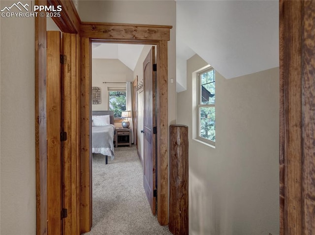 hall with light carpet and lofted ceiling