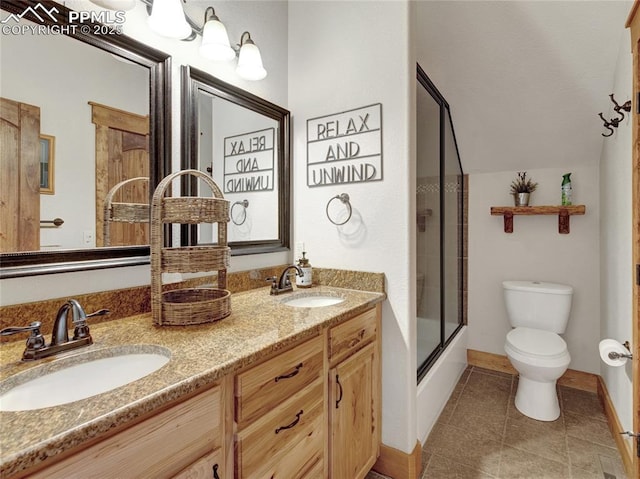 bathroom featuring tile patterned flooring, a sink, toilet, and double vanity