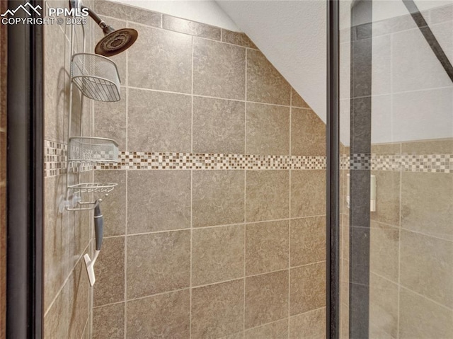 full bath featuring lofted ceiling and a stall shower