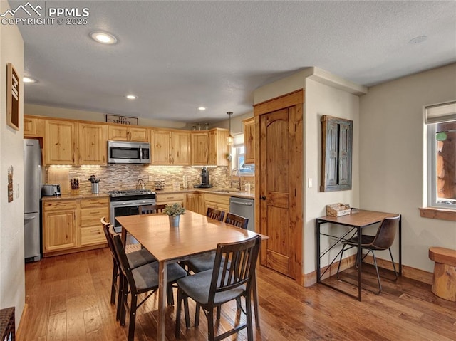 dining room with recessed lighting, baseboards, and wood finished floors