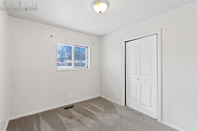 unfurnished bedroom featuring a closet and carpet flooring