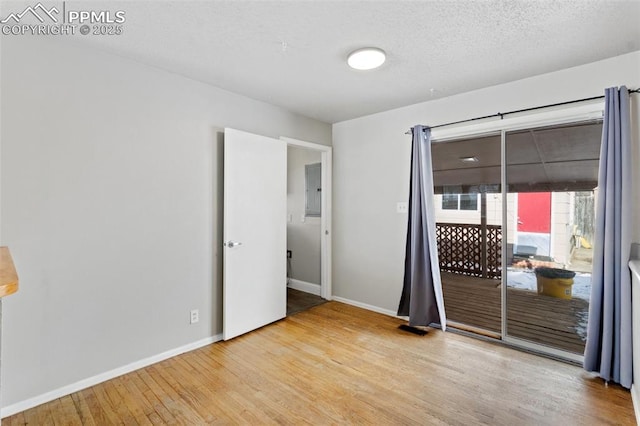 empty room with hardwood / wood-style flooring and a textured ceiling