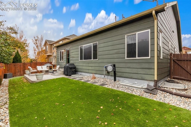 back of property with outdoor lounge area, a lawn, and a patio area