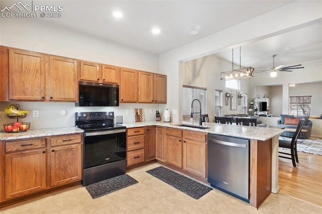 kitchen featuring appliances with stainless steel finishes, decorative light fixtures, sink, a high ceiling, and kitchen peninsula