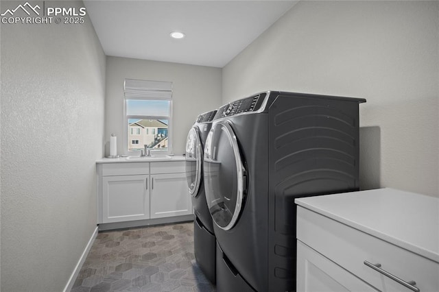 laundry room featuring cabinets, independent washer and dryer, and sink