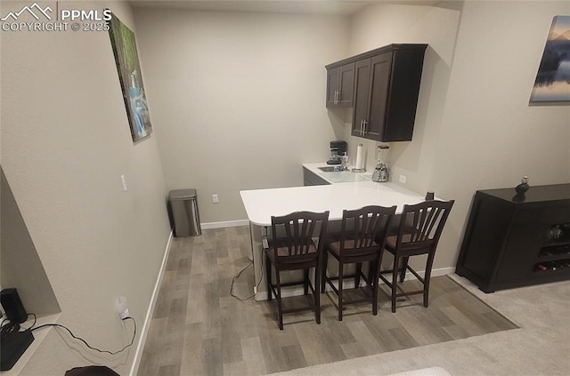 dining room with sink and light wood-type flooring