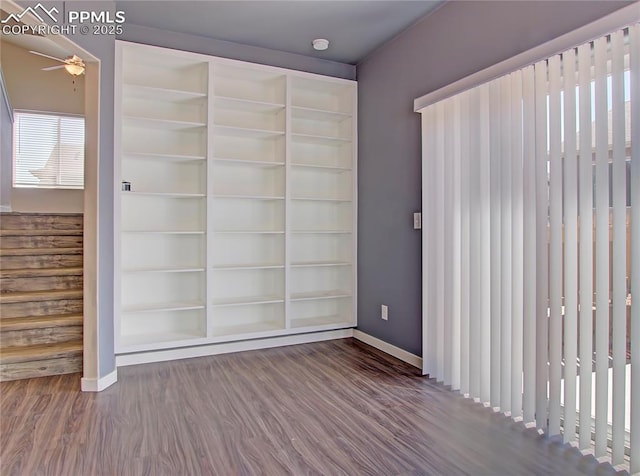 interior space with hardwood / wood-style floors, built in shelves, and ceiling fan