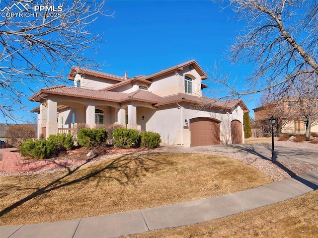 mediterranean / spanish-style house featuring a garage and a front lawn