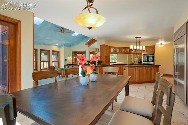 dining space with ceiling fan with notable chandelier