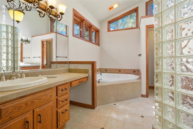 bathroom featuring vaulted ceiling, a relaxing tiled tub, tile patterned floors, and vanity