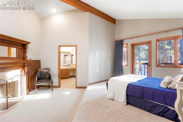 bedroom with connected bathroom, high vaulted ceiling, a tiled fireplace, light colored carpet, and beam ceiling