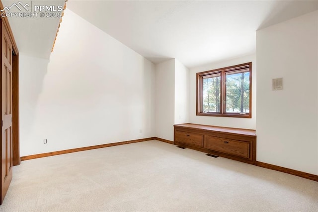 interior space with vaulted ceiling and light colored carpet