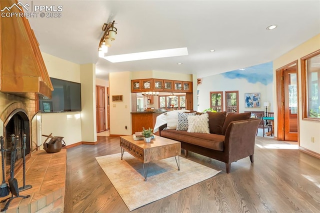 living room with hardwood / wood-style flooring and a brick fireplace