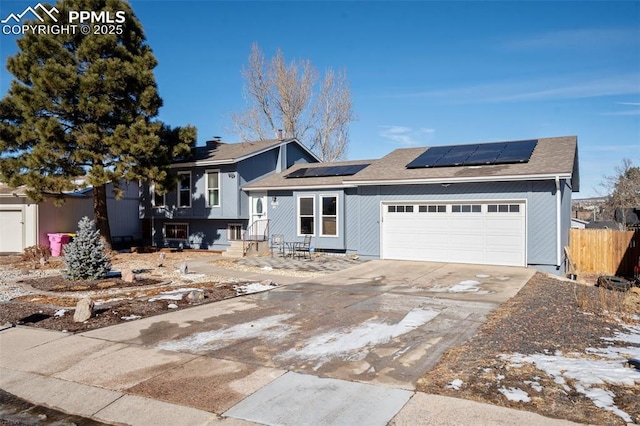 view of front of property with a garage and solar panels