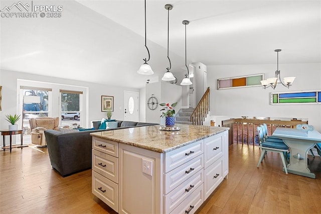 kitchen featuring pendant lighting, a notable chandelier, a center island, and light wood-type flooring