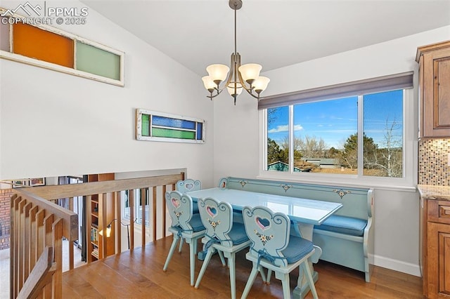 dining area featuring hardwood / wood-style flooring, lofted ceiling, and a chandelier