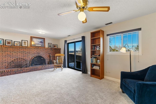 carpeted living room with a fireplace, a textured ceiling, and a wealth of natural light