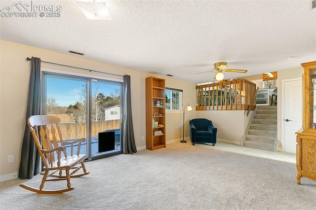 sitting room featuring a textured ceiling, light colored carpet, and ceiling fan