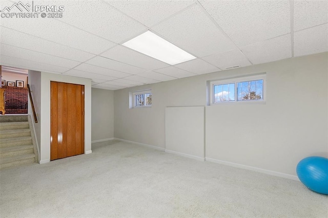 basement with light carpet and a drop ceiling