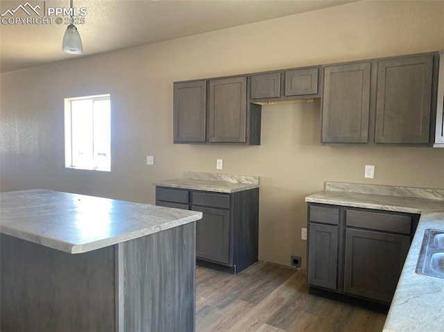 kitchen with dark wood-type flooring, decorative light fixtures, and sink