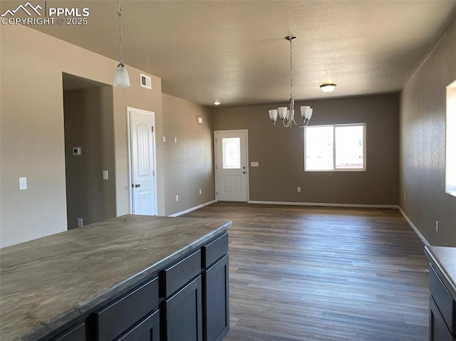 kitchen featuring pendant lighting, an inviting chandelier, and dark wood-type flooring