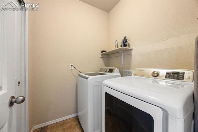 laundry room with tile patterned floors and washer and clothes dryer