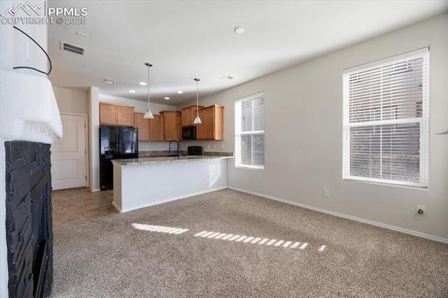 kitchen with pendant lighting, kitchen peninsula, sink, light colored carpet, and black appliances