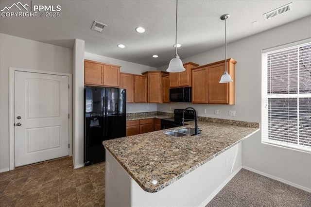 kitchen with pendant lighting, black appliances, sink, light stone counters, and kitchen peninsula