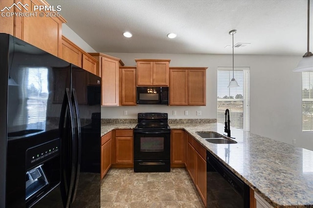 kitchen featuring sink, decorative light fixtures, kitchen peninsula, light stone countertops, and black appliances