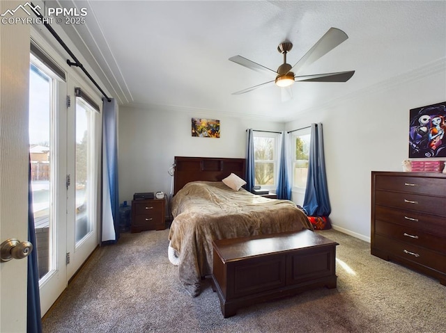 carpeted bedroom with baseboards, multiple windows, ornamental molding, and a ceiling fan