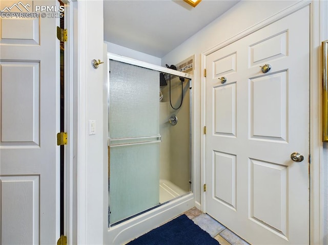 full bathroom featuring a stall shower and tile patterned flooring